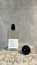 Echo Notes 2020 perfume bottle surrounded by fresh blood oranges, dewy violet leaves, jasmine sambac, and lotus blossoms.