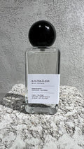 Echo Notes Animalique perfume bottle surrounded by bergamot, lemon slices, delicate violet blooms, soft suede, and tobacco leaves.