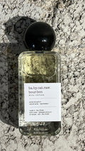 Echo Notes Babycat Raw Bourbon perfume bottle surrounded by black and pink peppercorns, saffron threads, and vanilla pods.