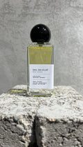 Echo Notes Bleu L’Exclusif perfume bottle surrounded by fresh bergamot, juniper berries, cardamom pods, black peppercorns, and cedar.