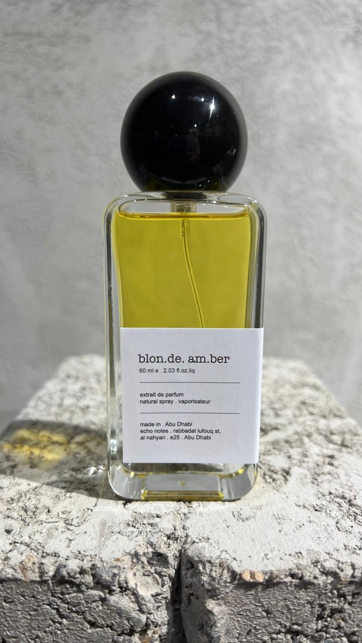Echo Notes Blonde Amber perfume bottle surrounded by rum, olibanum, dried fruits, white tobacco, sandalwood, and vanilla pods.