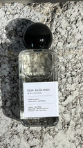 Echo Notes Blue Talisman perfume bottle surrounded by fresh pear, bergamot citrus, ginger root, and modern woody notes.