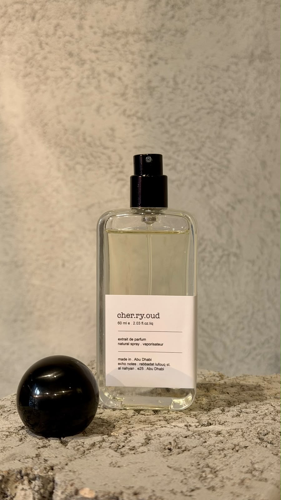 Echo Notes Cherry Oud perfume bottle framed by juicy red cherries, dark rose petals, agarwood, and supple leather.