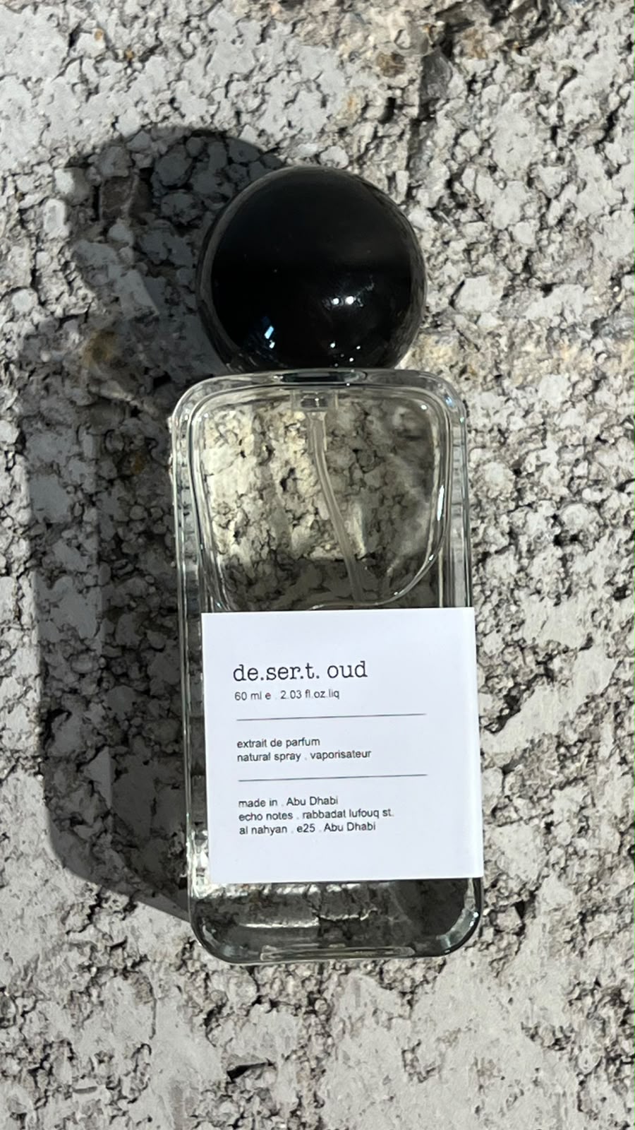 Echo Notes Desert Oud perfume bottle surrounded by burning incense resins, dark agarwood, warm amber stones, and musk.
