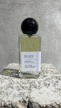 Echo Notes Dear Polly perfume bottle surrounded by fresh bergamot, red apple slices, dark black tea leaves, and black amber.