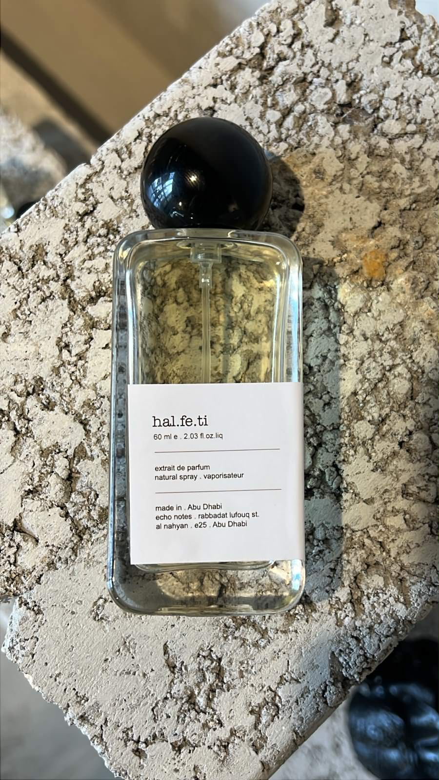 Echo Notes Halfeti perfume bottle framed by vibrant saffron, deep Bulgarian rose petals, and dark agarwood oud.