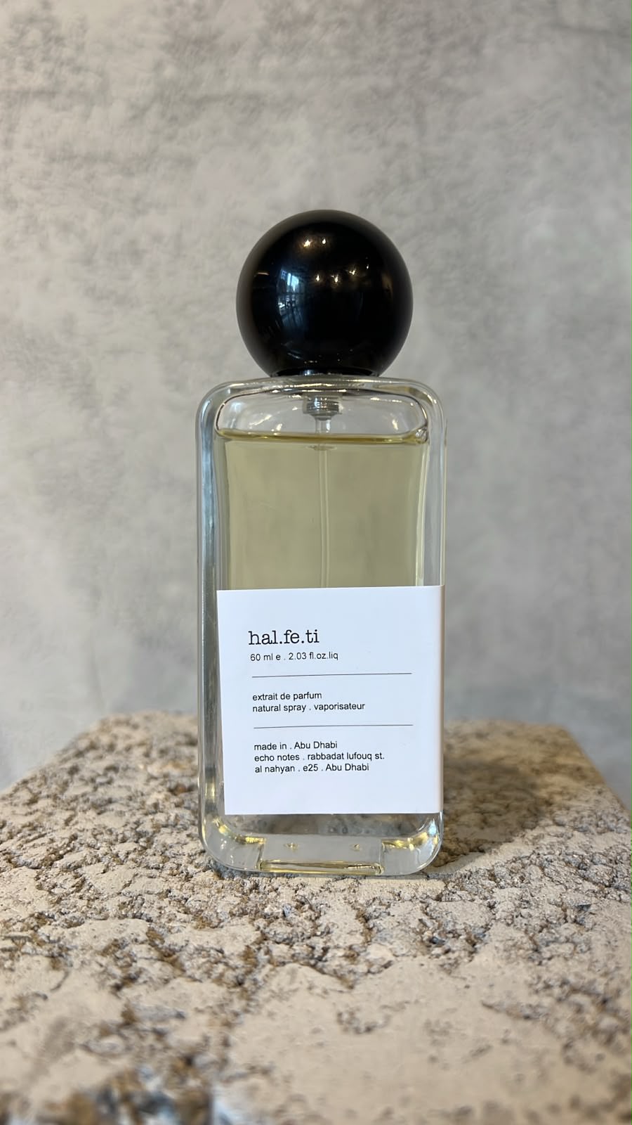 Echo Notes Halfeti perfume bottle framed by vibrant saffron, deep Bulgarian rose petals, and dark agarwood oud.