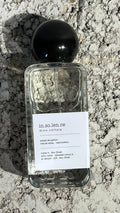 Echo Notes Insolence perfume bottle surrounded by ripe raspberries, red berries, purple violet blooms, and powdery iris roots.