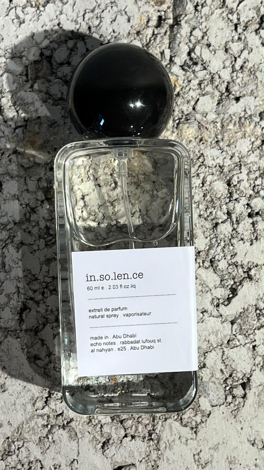 Echo Notes Insolence perfume bottle surrounded by ripe raspberries, red berries, purple violet blooms, and powdery iris roots.