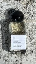 Echo Notes Joy perfume bottle surrounded by sparkling bergamot, Grasse rose petals, and soft white musk.