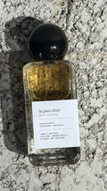 Echo Notes La Panthere Extrait perfume bottle surrounded by dried fruits, ripe strawberries, and white gardenia petals.