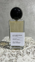 Echo Notes Midnight Bloom perfume bottle surrounded by pineapple chunks, saffron threads, rose petals, orange blossom, and leather.