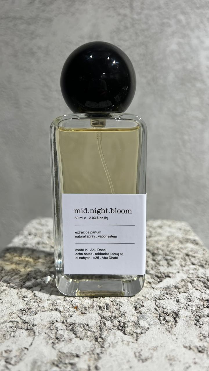 Echo Notes Midnight Bloom perfume bottle surrounded by pineapple chunks, saffron threads, rose petals, orange blossom, and leather.