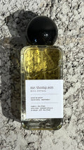 Echo Notes The Omniscient Mr Thompson perfume bottle surrounded by lavender flowers, pink peppercorns, and vanilla beans.