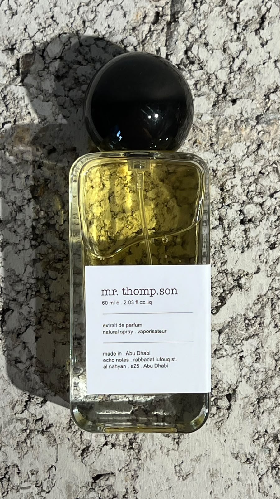 Echo Notes The Omniscient Mr Thompson perfume bottle surrounded by lavender flowers, pink peppercorns, and vanilla beans.