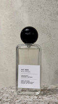 Echo Notes Mr Sam perfume bottle surrounded by aromatic cardamom pods, cinnamon sticks, black pepper, and rich tobacco leaves.