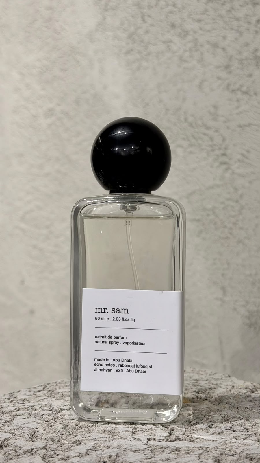 Echo Notes Mr Sam perfume bottle surrounded by aromatic cardamom pods, cinnamon sticks, black pepper, and rich tobacco leaves.