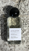 Echo Notes Peche Mirage perfume bottle surrounded by fresh ripe peaches, golden osmanthus blossoms, and supple leather.