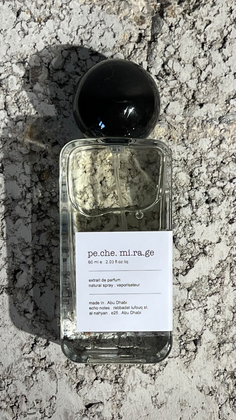 Echo Notes Peche Mirage perfume bottle surrounded by fresh ripe peaches, golden osmanthus blossoms, and supple leather.
