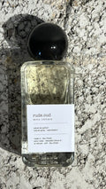 Echo Notes Rude Oud perfume bottle surrounded by sweet raspberries, golden saffron, dark agarwood oud, and warm amber.