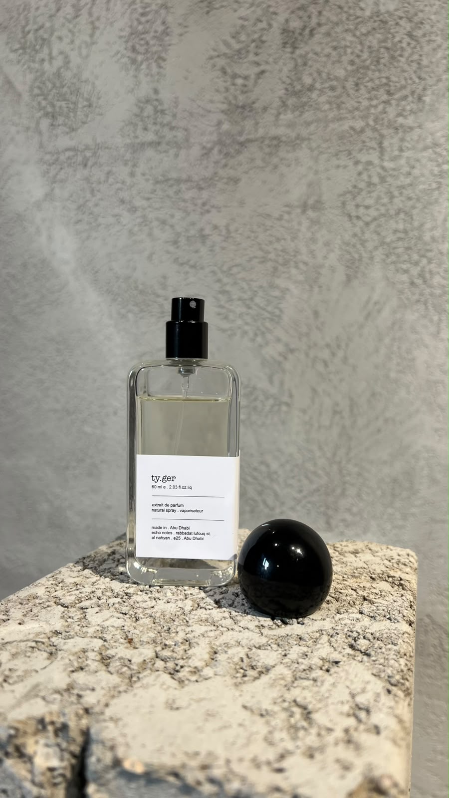 Echo Notes Tygar perfume bottle surrounded by fresh grapefruit halves, sliced ginger root, and crystalline ambroxan.