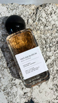 Echo Notes Armani Prive Vert Malachite perfume bottle surrounded by bitter orange leaves, jasmine sambac flowers, and vanilla pods.